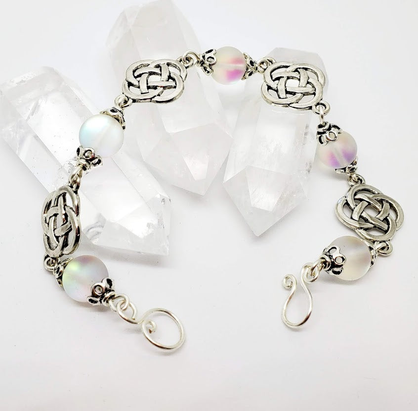 9" Celtic Themed Bracelet with 'Mermaid Beads'. These beads have a 'flash' like laborite or other illuminate stones. Handmade hook/eye clasp. Nickel-free silver tone metal.