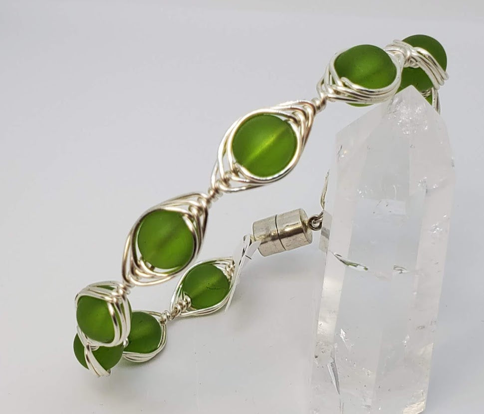 Green Sea Glass with herringbone wrapped wire. 20 gauge artistic wire in silver with magnetic clasp. Very attractive Bangle style