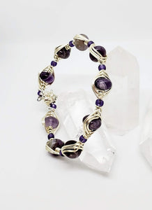 10mm rondell Amethyst Gemstone wrapped in 18 gauge artistic wire. Magnetic clasp with safety chain. Fits average wrist of 7 inches This bracelet has a bold look with the 18 g wire.