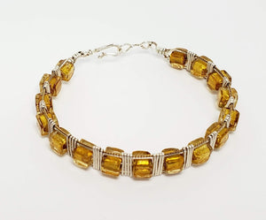This Bracelet adds a touch of elegance to any outfit. Gold Foil cubed glass beads wrapped in silver & gold plated copper wire. Mixing metal colors is the current trend and allows you more options to mix and match your jewelry. The decorative twisted wire edge adds some texture to this piece. Oval bracelets tend to be more comfortable, especially if doing desk work. 